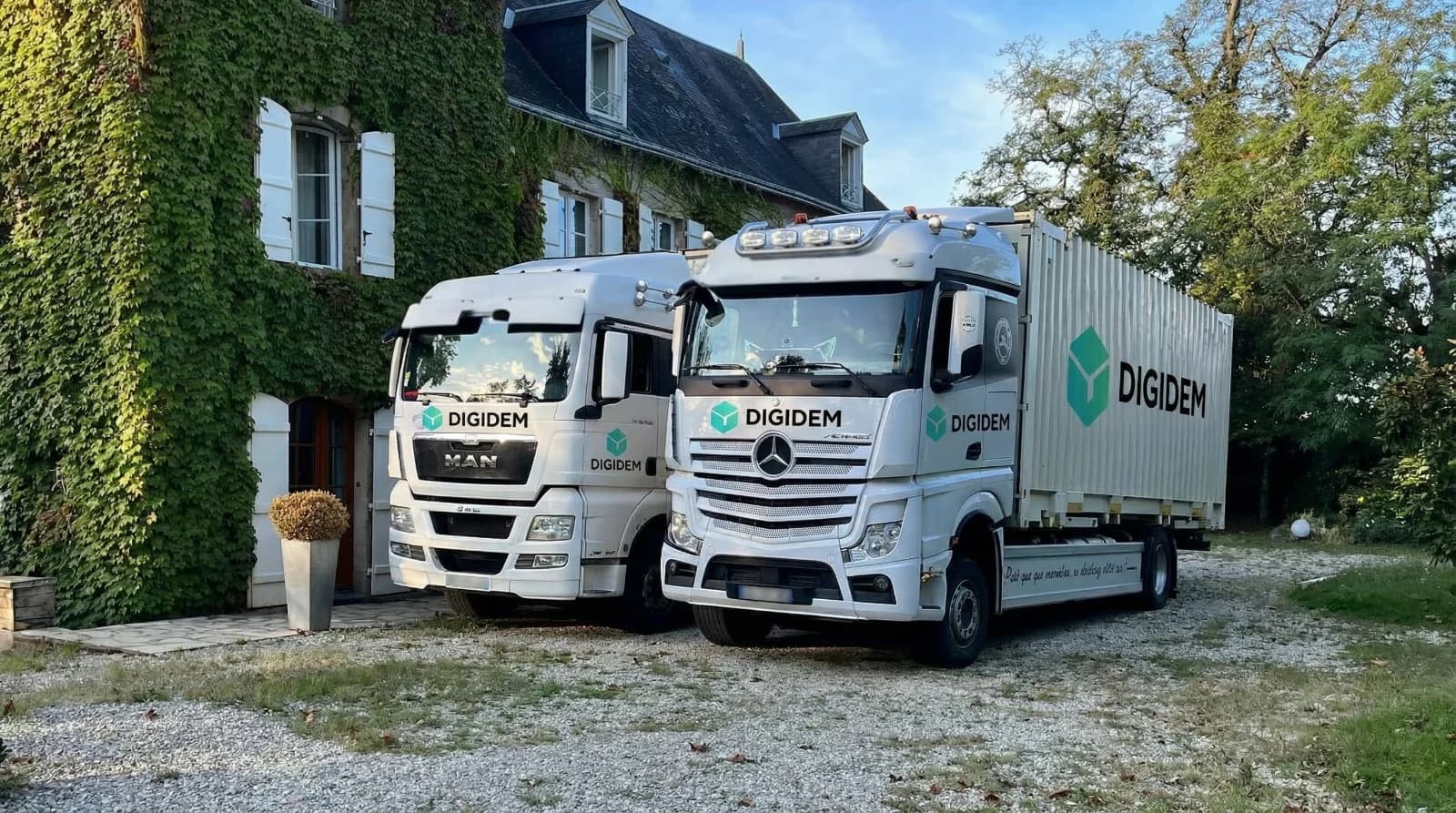 Flotte de camions de déménagement Digidem devant une maison