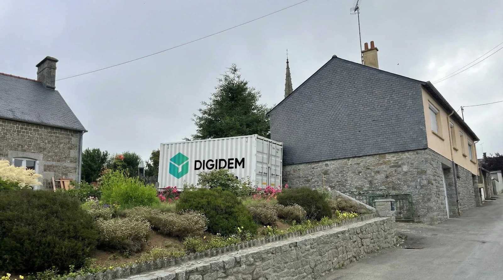 Livraison de container Digidem devant des maisons en pierre